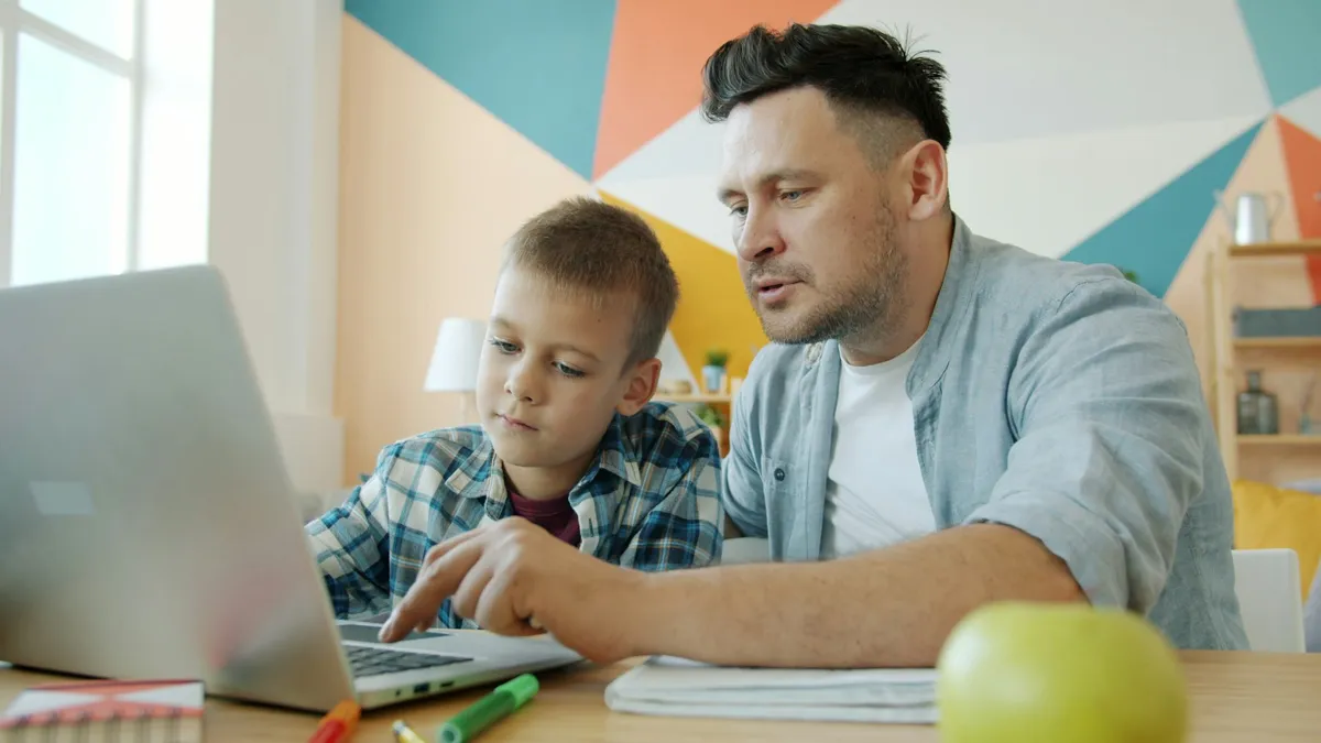 Father and son learning together at a laptop